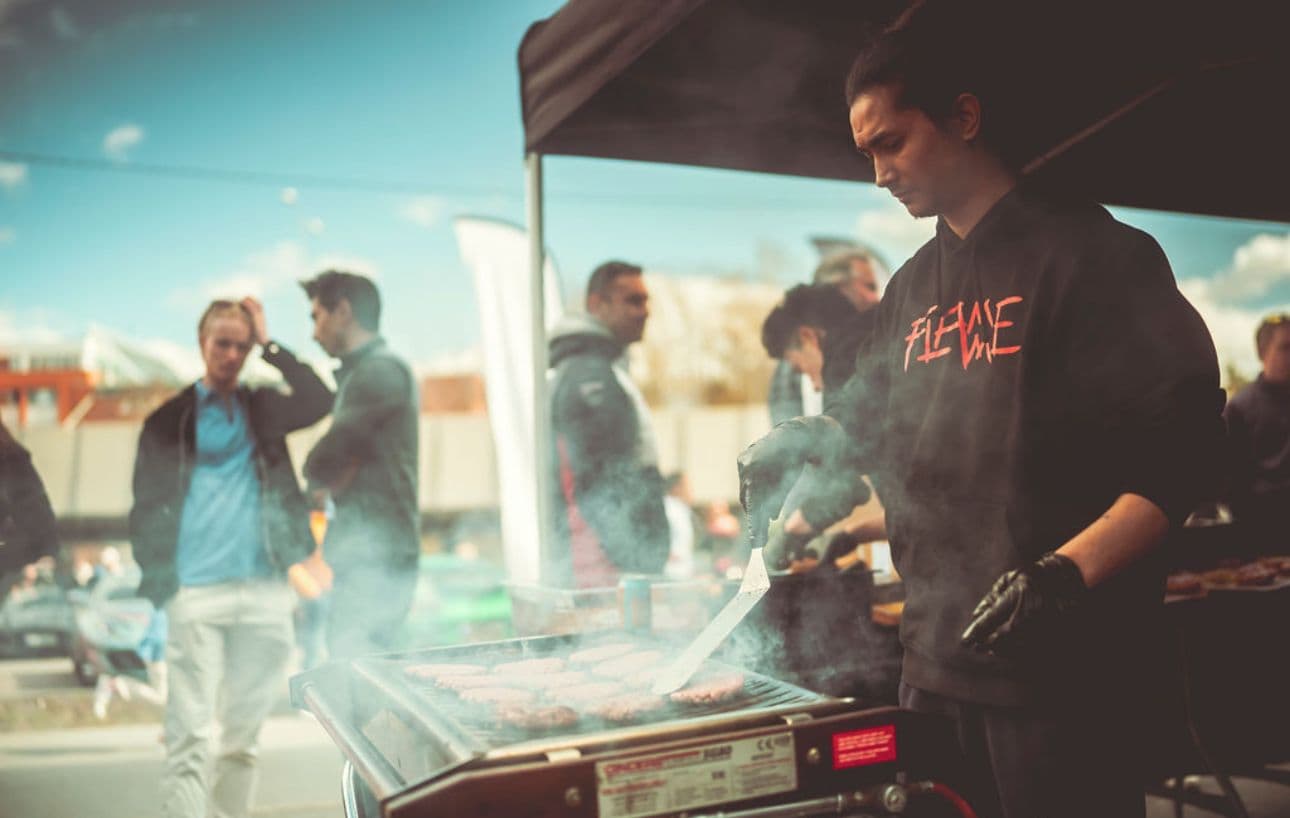 Mann lager burger på grill
